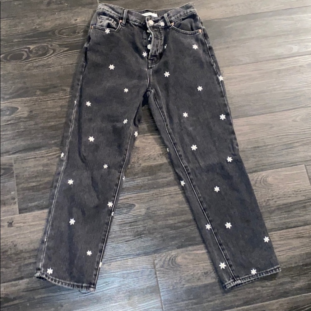 Black jeans with small yellow and white daisies
